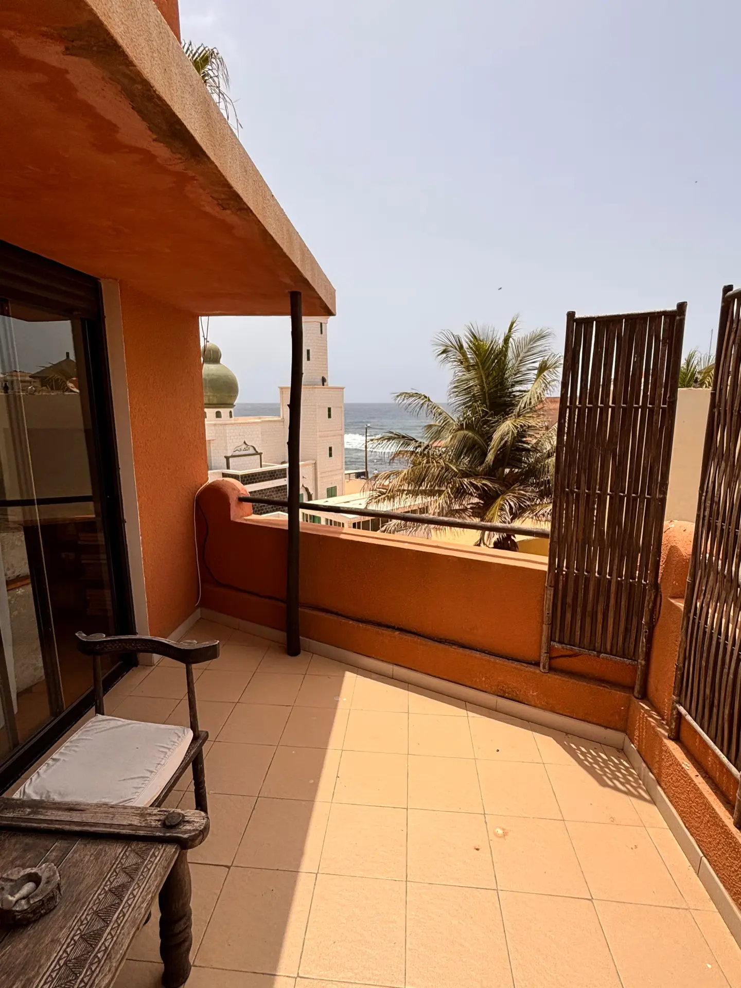 Private terracotta balcony with ocean, mosque minaret and palm views