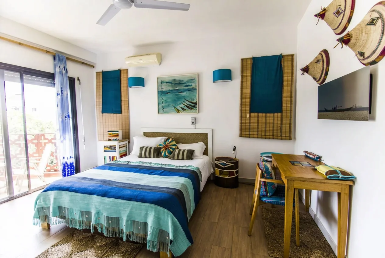 Light-filled bedroom with blue accents, ceiling fan and woven baskets on the wall