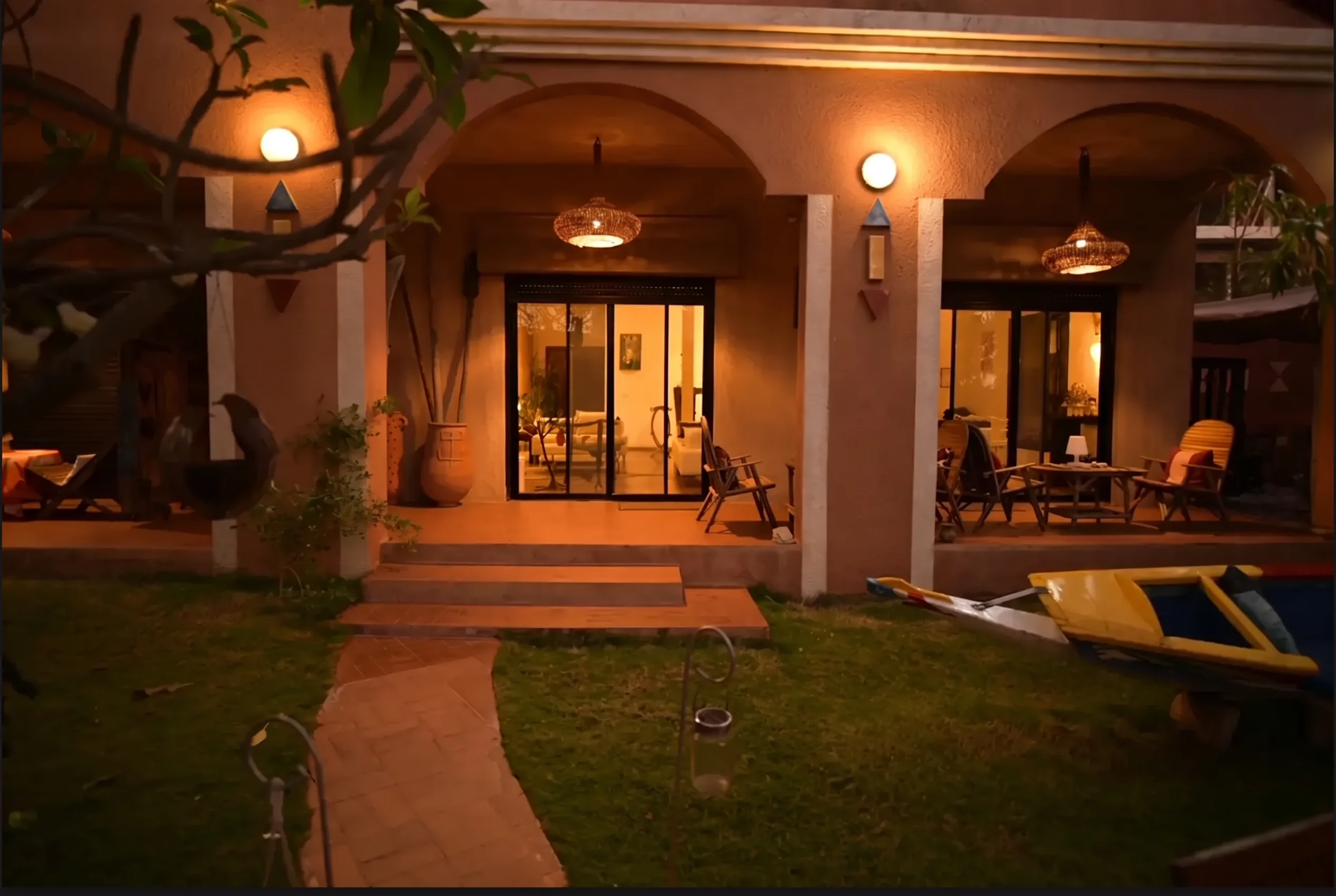 Arched garden veranda of Maison Sahel lit warmly at night